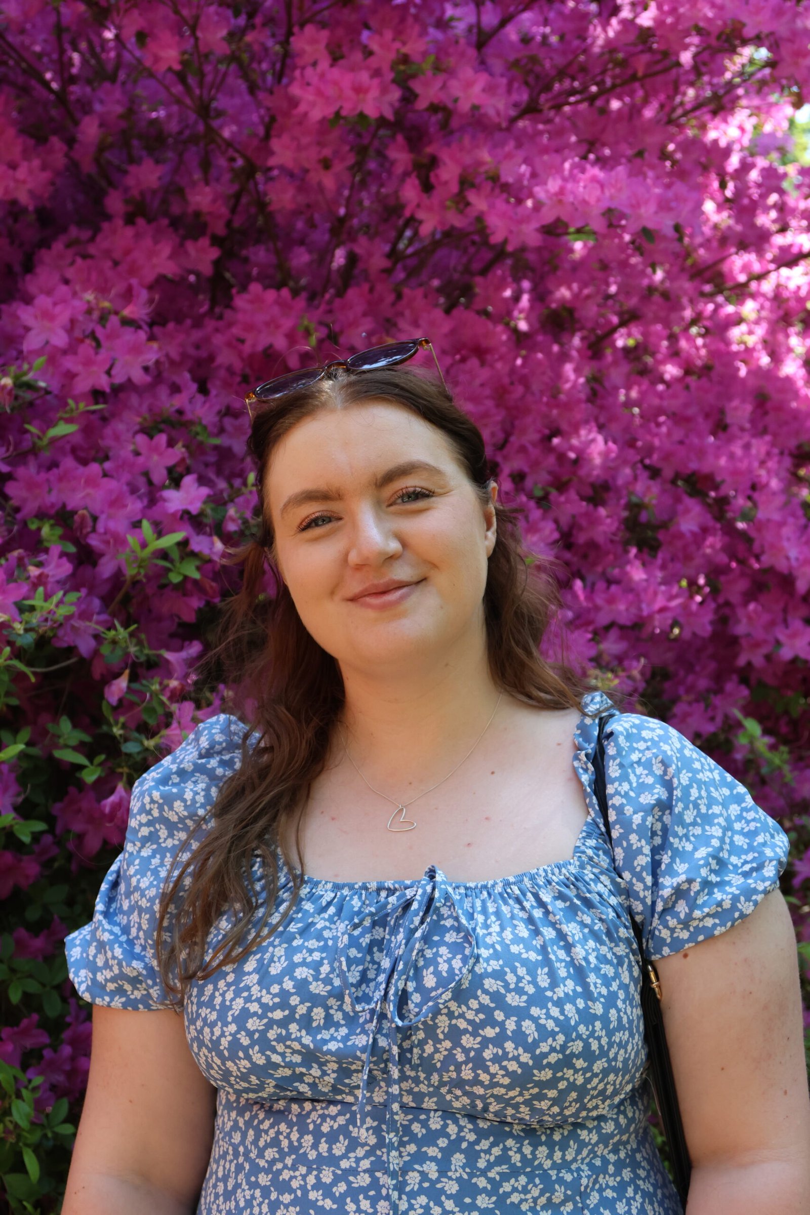 Picture of Becky in front of a large flower bush